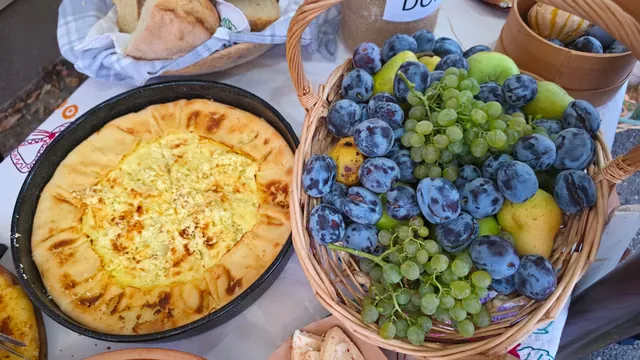 Košara šljiva, grožđa i krušaka uz pitu