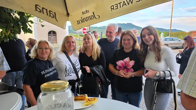 Nasmijane gošće poziraju pod suncobranom ispred doma