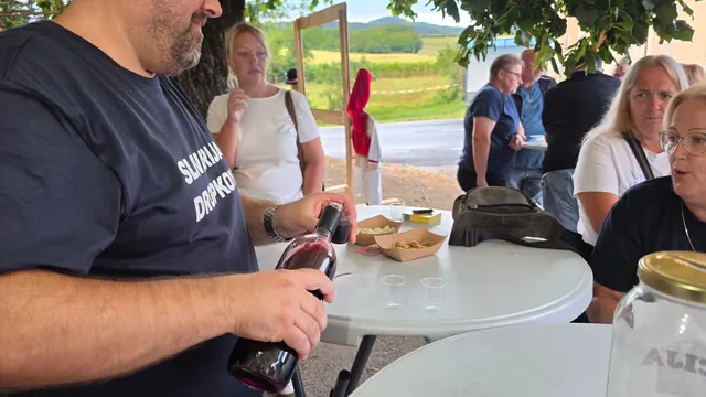 Član ekipe toči rakiju gostima za stolom
