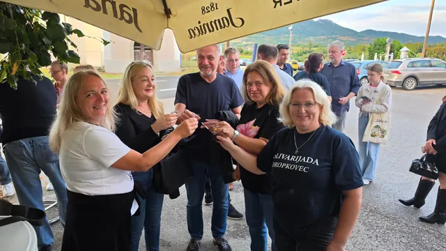 Veselo društvo nazdravlja čašicama ispred doma