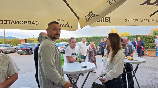 Gosti razgovaraju za visokim stolovima na otvorenom