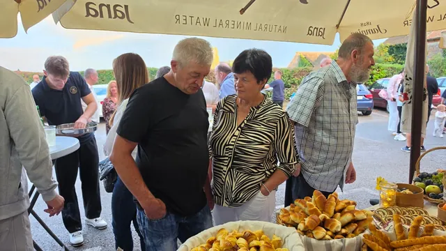 Gosti razgledavaju stol s domaćim kiflicama i kolačima