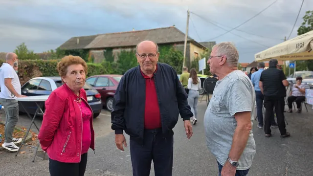 Troje starijih gostiju razgovara na parkiralištu