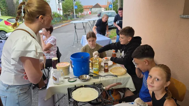 Djeca peku palačinke na plinskom kuhalu ispred doma