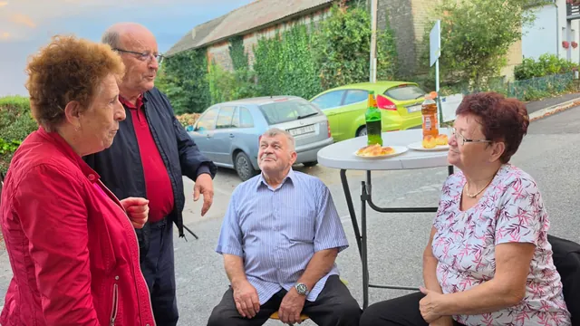 Stariji gosti uz kolače za visokim stolom vani