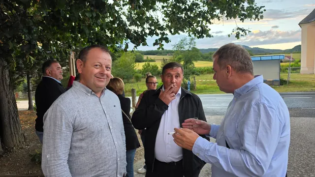 Gosti razgovaraju i puše ispred doma u predvečerje