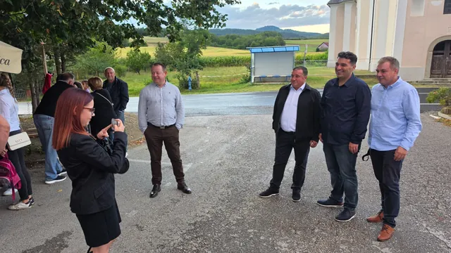 Djevojka fotografira skupinu gostiju ispred crkve