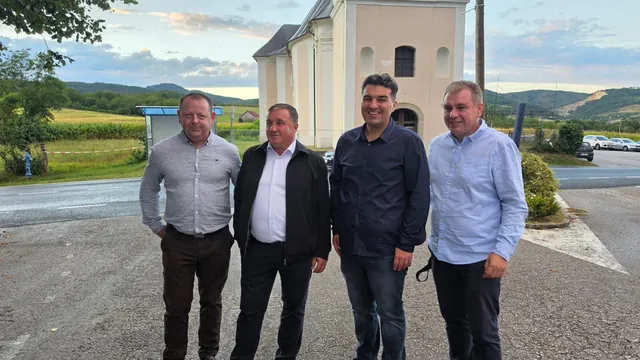 Četvorica muškaraca poziraju ispred kapele s brežuljcima u pozadini
