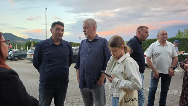 Gosti razgovaraju na parkiralištu u predvečerje