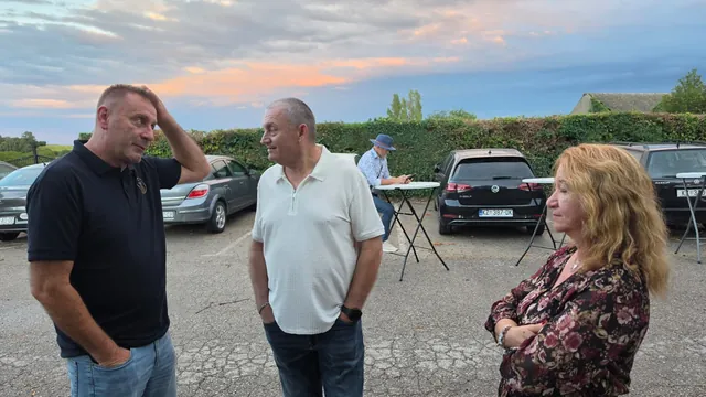 Gosti čavrljaju na parkiralištu uz stolove za stajanje