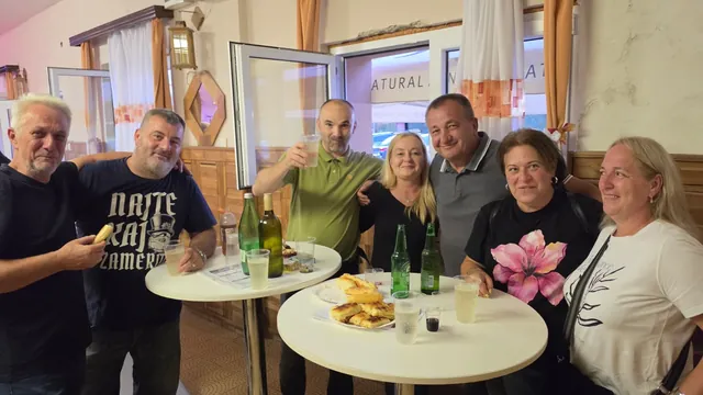 Veselo društvo nazdravlja uz kolače za stolovima u dvorani