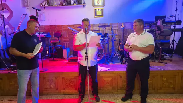 Voditelji čitaju rezultate ocjenjivanja ispred pozornice