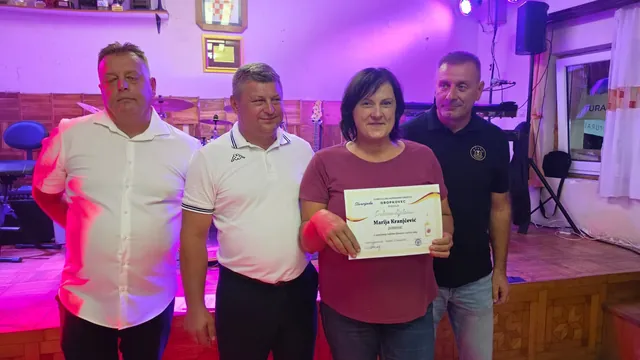 Dobitnica srebrne diplome pozira s domaćinima ispred pozornice