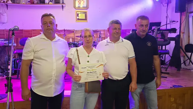 Dobitnica zlatne diplome s djevojčicom i domaćinima