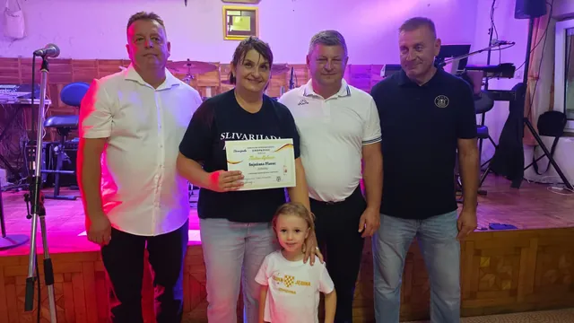 Dobitnica zlatne diplome pozira s domaćinima u dvorani