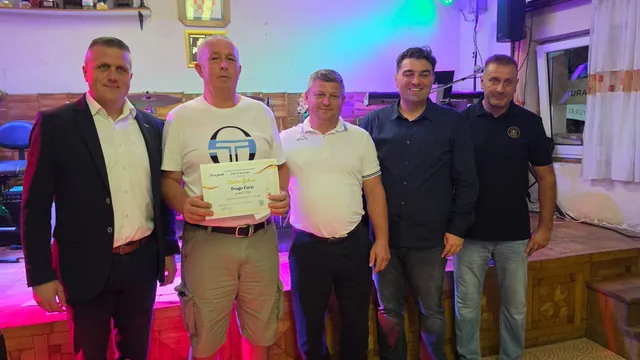 Dobitnik zlatne diplome pozira ispred pozornice