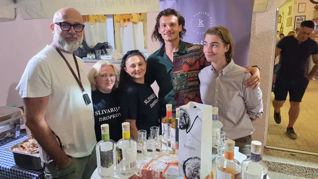 Ekipa uz štand destilerije Korijen s bocama rakija