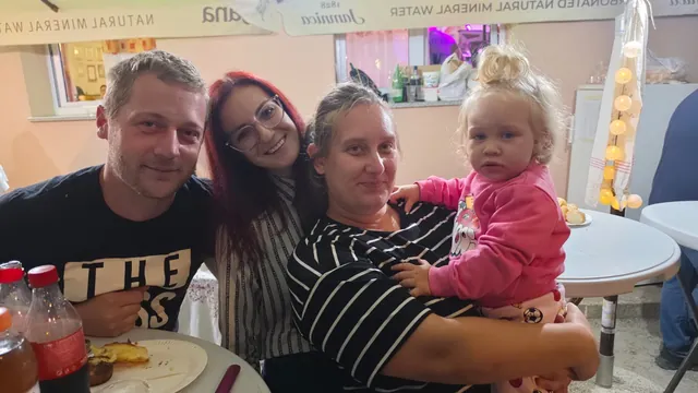 Obitelj s malom djevojčicom za stolom u večernjim satima