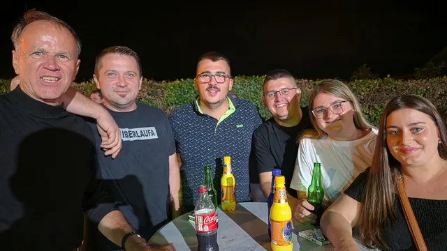 Veselo društvo okupljeno oko stola s osvježavajućim pićima navečer