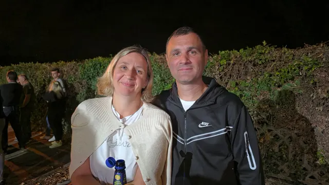Par pozira ispred živice u večernjoj atmosferi manifestacije