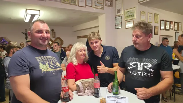 Društvo pozira uz stol s pićima u punoj dvorani