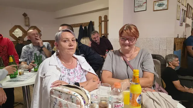 Dvije žene za stolom u večernjoj atmosferi dvorane