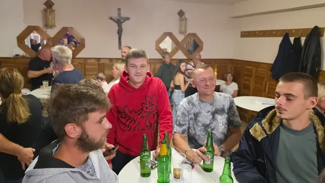 Mladići uz stol s pićem u punoj dvorani