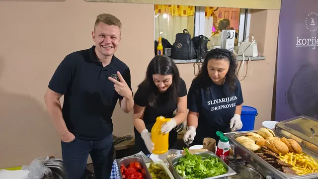 Ekipa priprema hamburgere s povrćem i pecivima na štandu